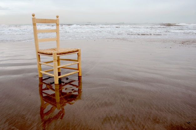 Chair on a beach in the water.